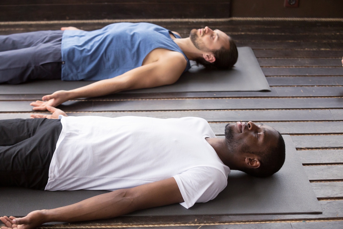men laying on yoga mats meditating